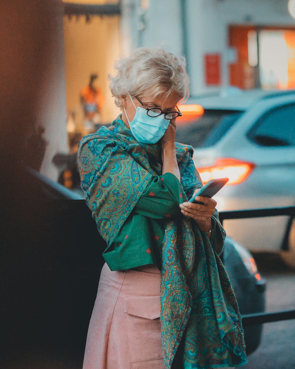 a woman wearing a face mask while looking at her cell phone