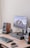a computer desk with a keyboard, mouse, speakers and a monitor