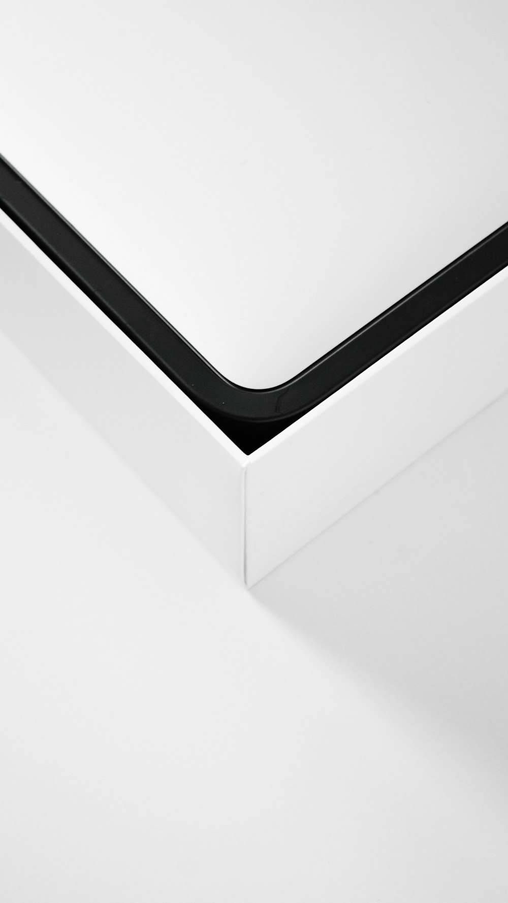a close up of a white surface with a black edge