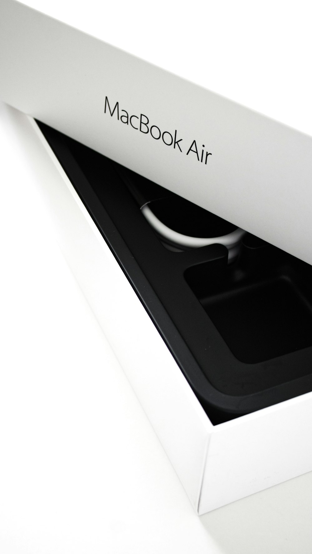an open macbook air box sitting on top of a table