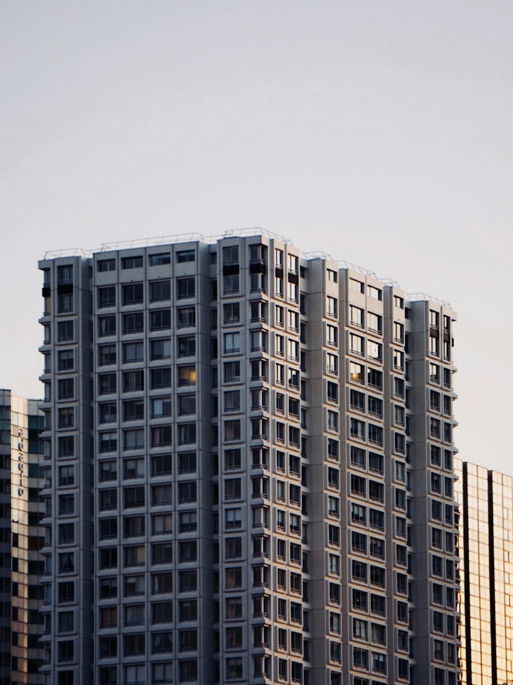 a very tall building with a plane flying in front of it