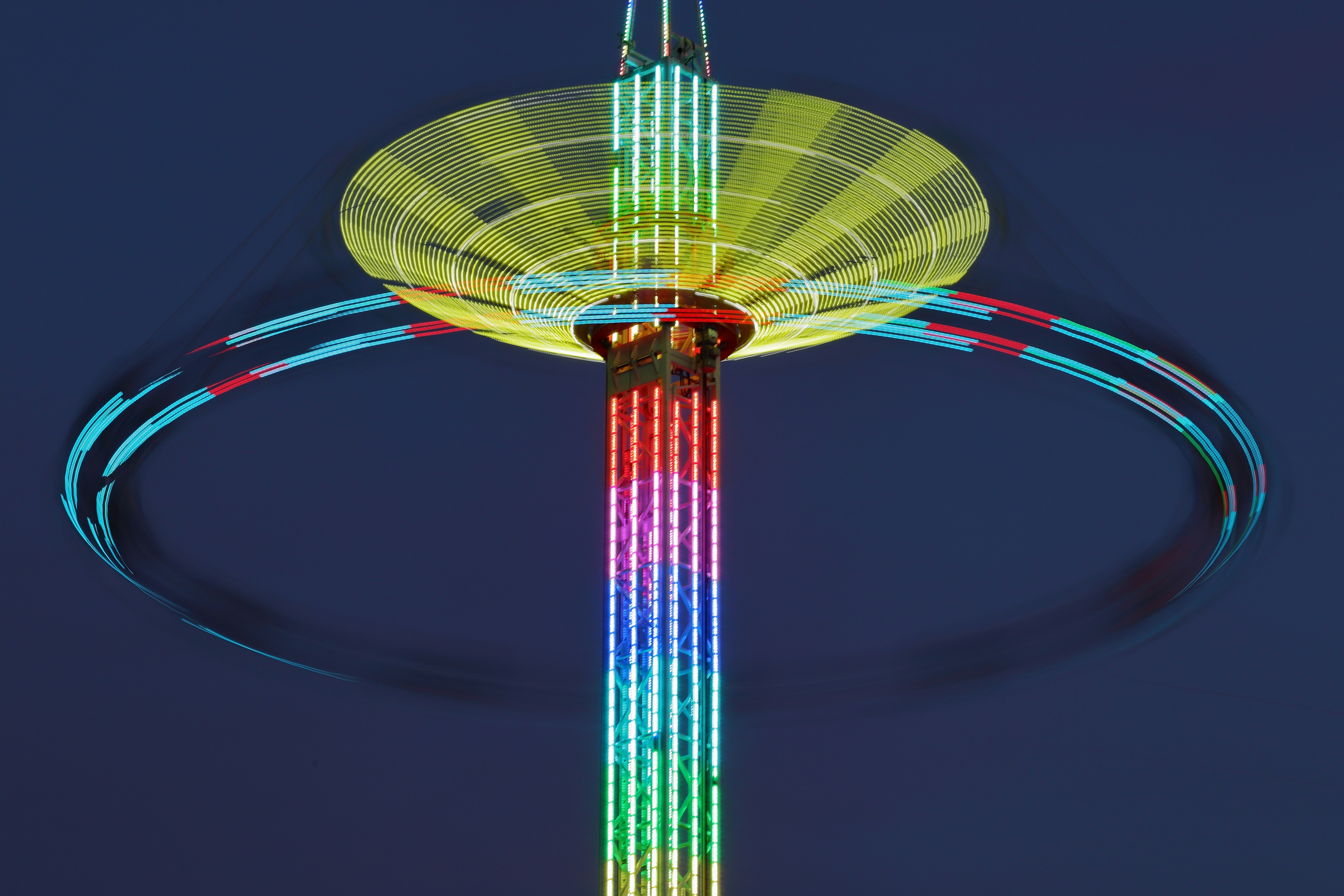 a ferris wheel spinning in the sky at night