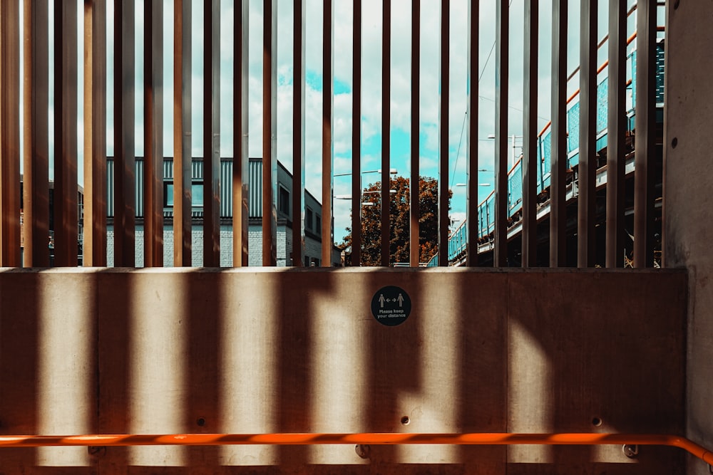 a bench sitting in front of a metal fence