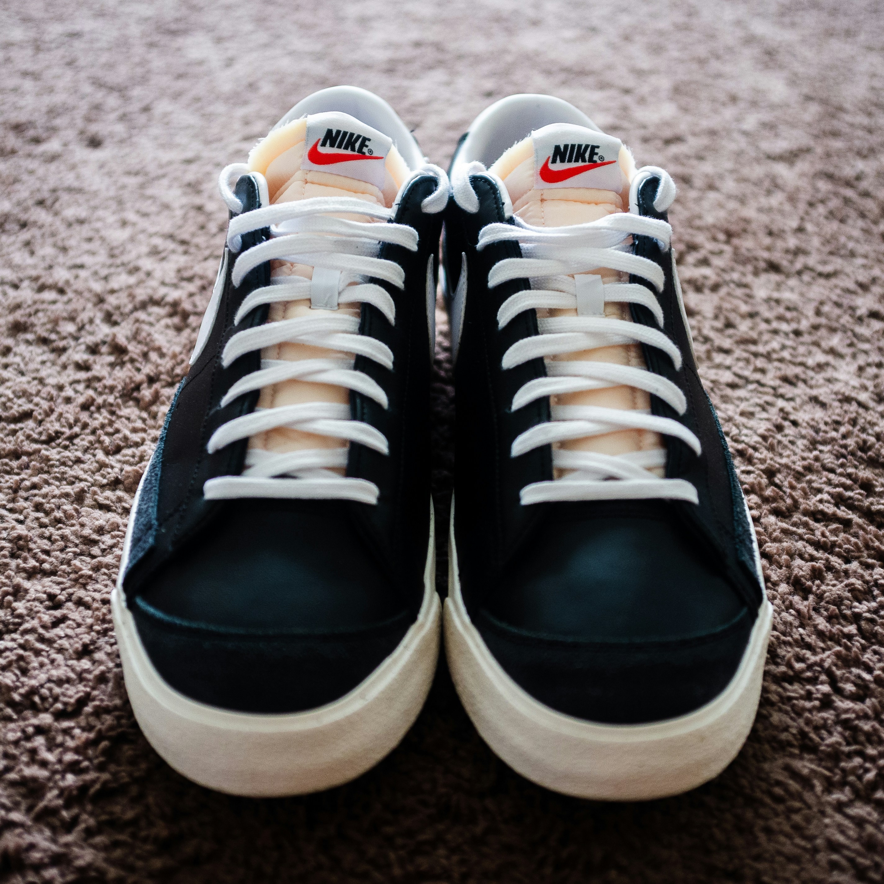 a pair of black and white sneakers on a carpet