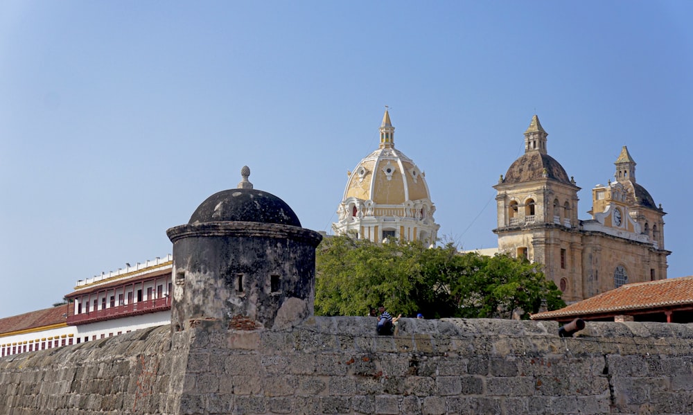 a stone wall with a building in the background