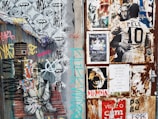 a wall covered in lots of graffiti next to a fire hydrant
