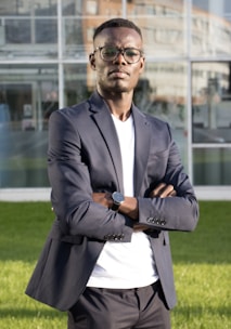 a man standing in front of a building with his arms crossed