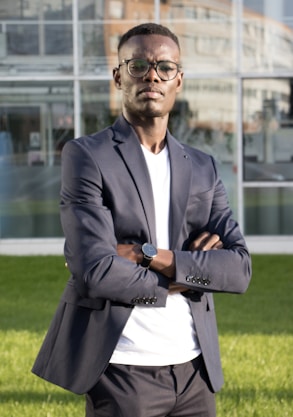 a man standing in front of a building with his arms crossed