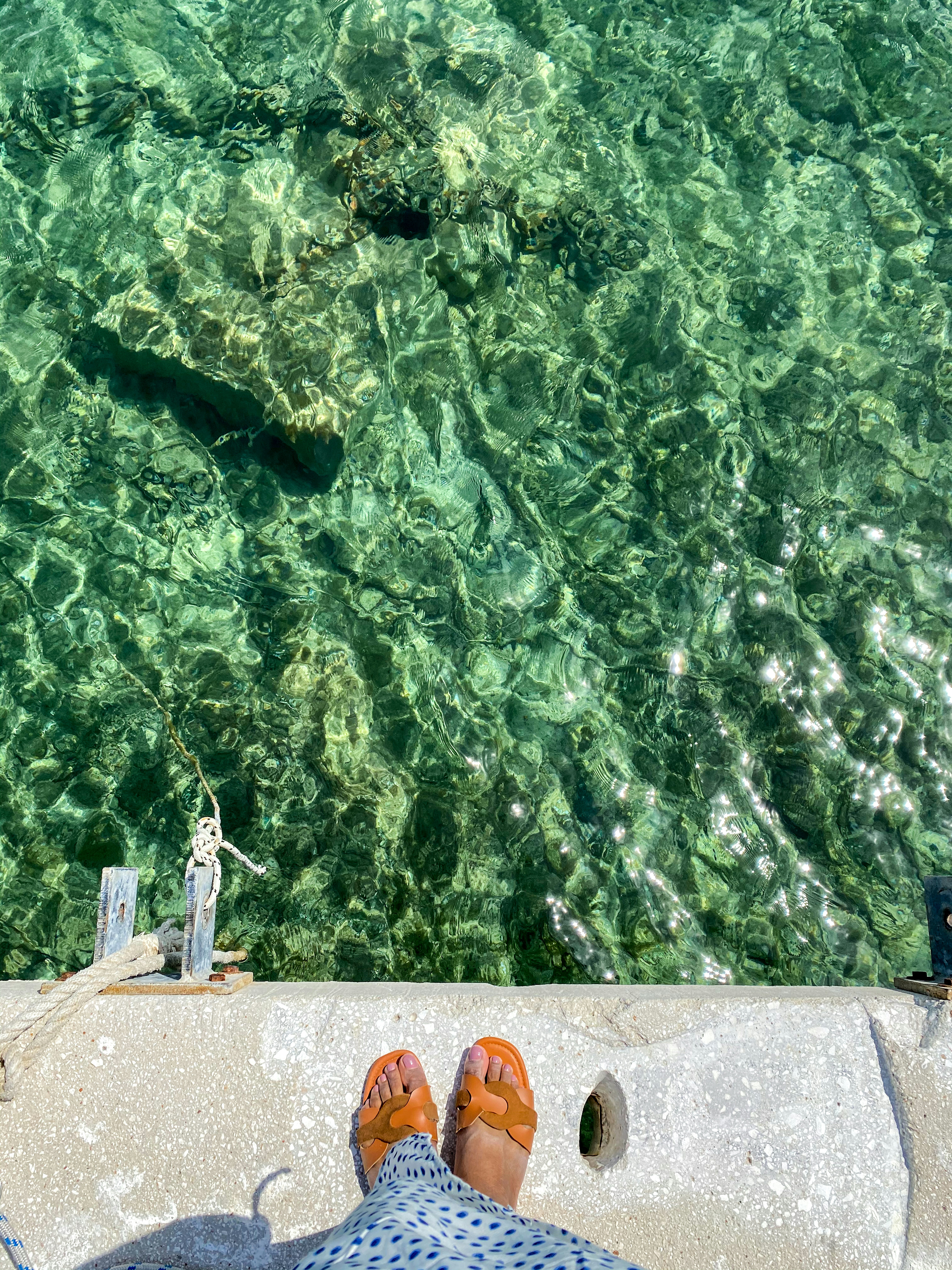 a person standing on a dock with their feet in the water