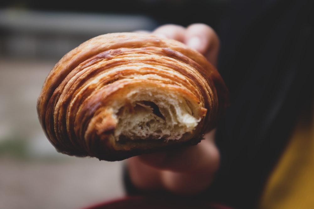 a close up of a person holding a pastry