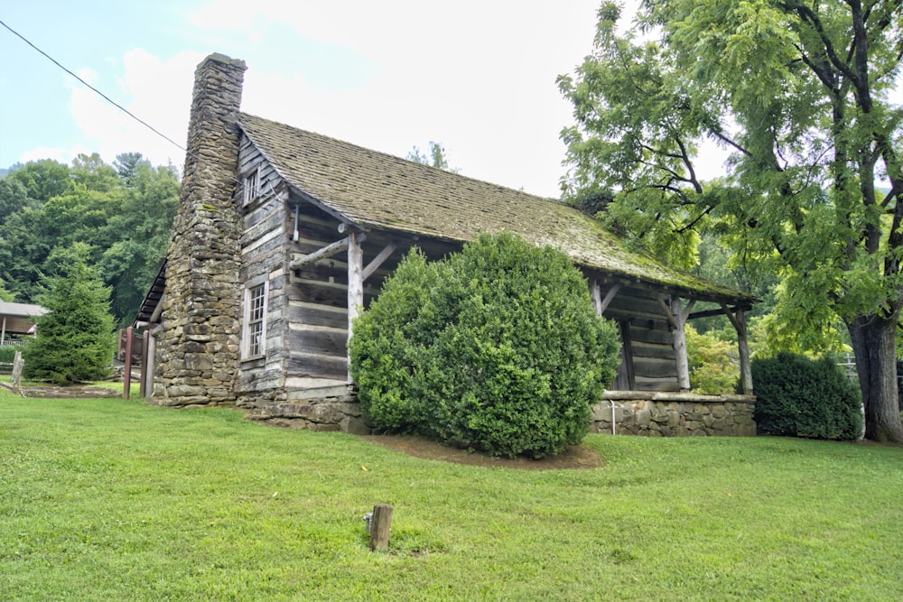 an old log cabin with a stone chimney