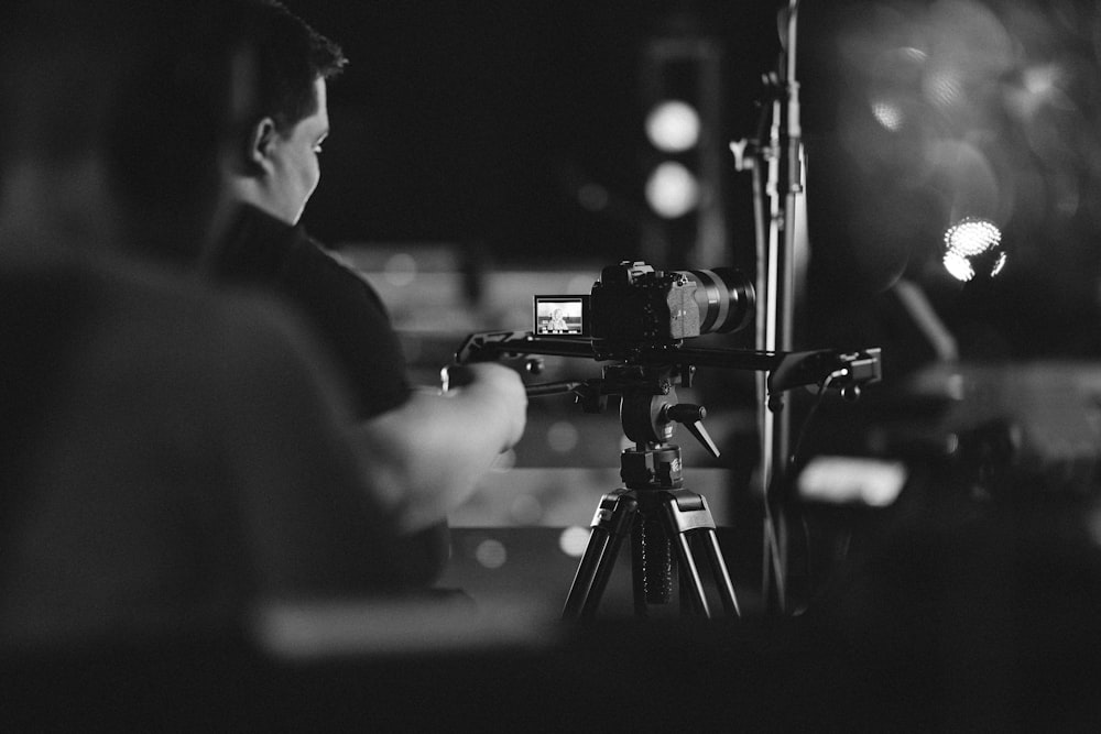 a man sitting in front of a camera on a tripod