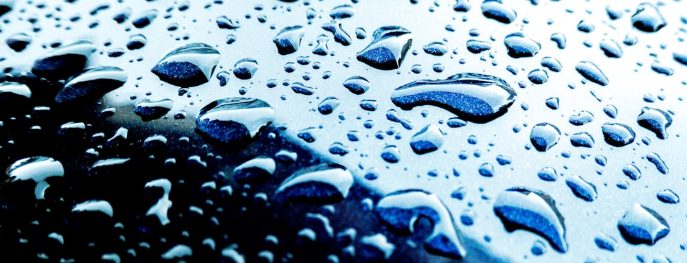 a close up of water droplets on a car