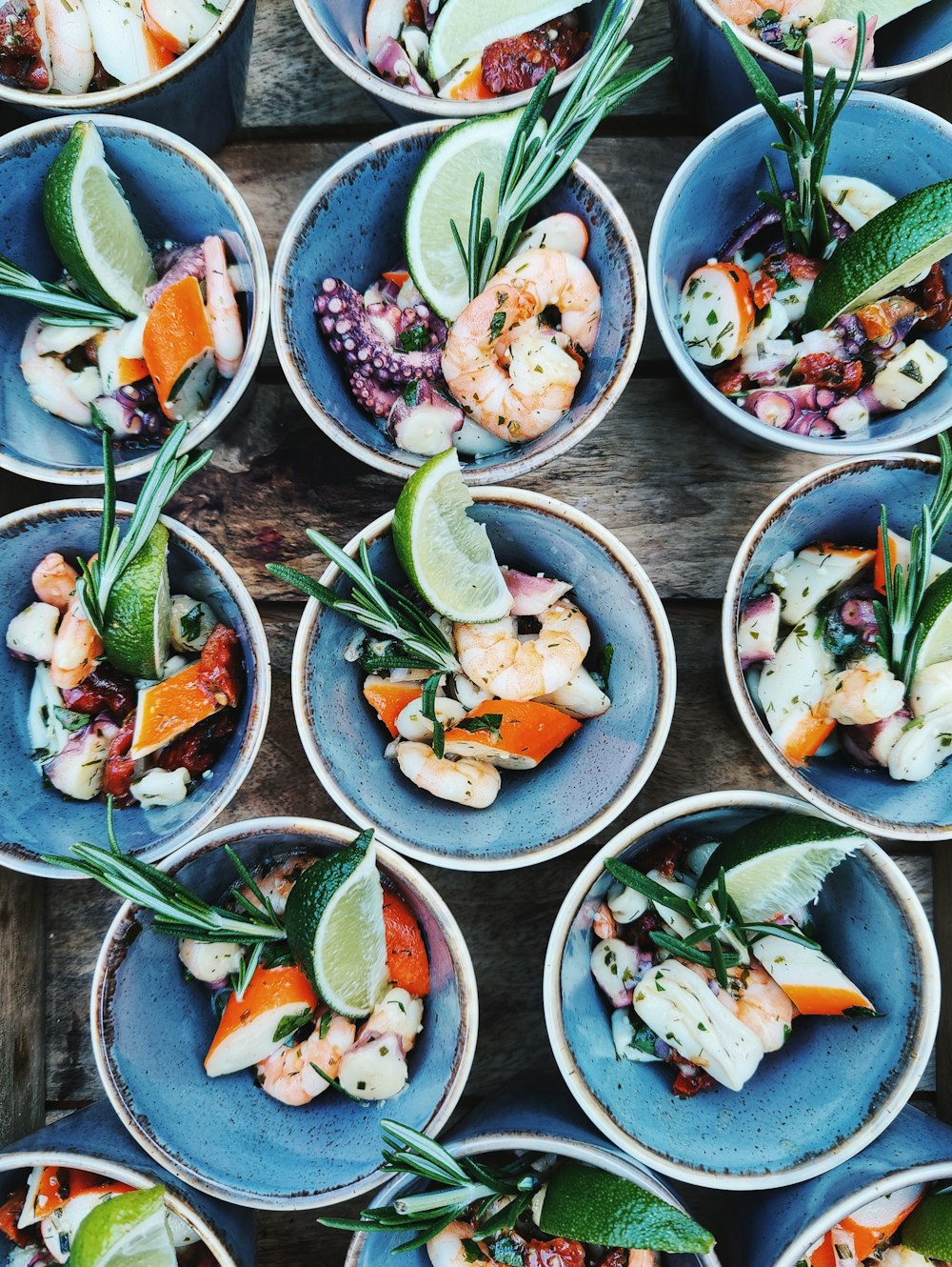 a table topped with blue bowls filled with different types of food