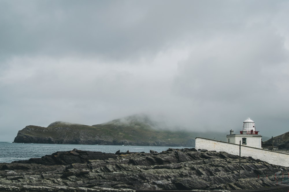a lighthouse on a rocky shore on a cloudy day
