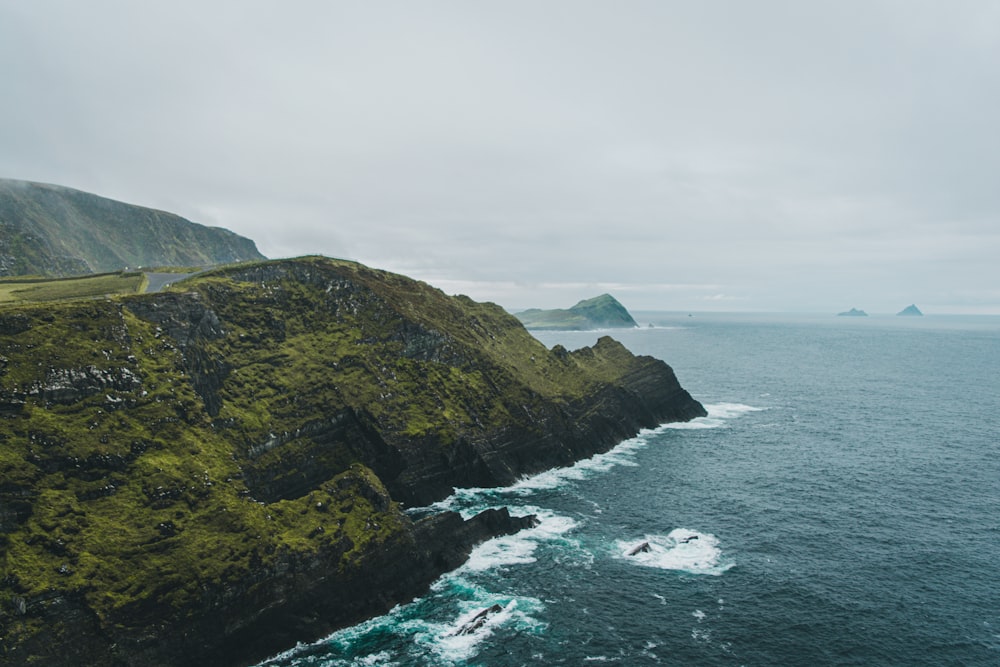 una gran masa de agua junto a una exuberante ladera verde