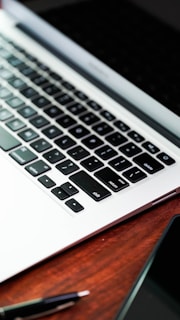 a laptop computer sitting on top of a wooden desk