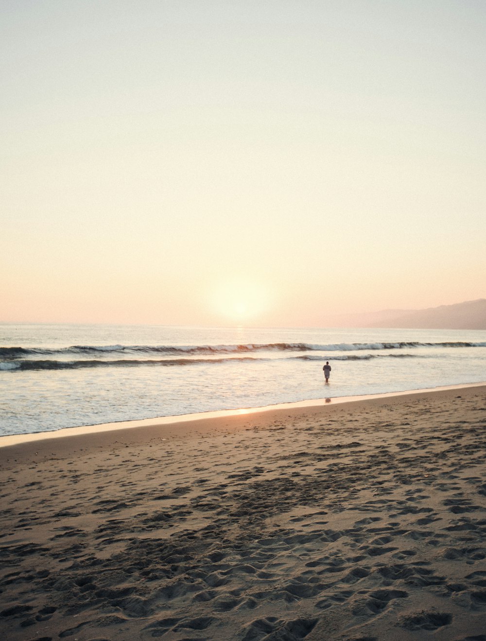 a person walking on a beach near the ocean