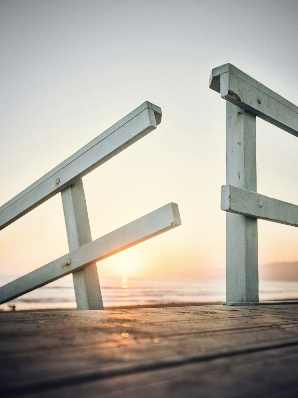 a couple of benches sitting on top of a wooden pier