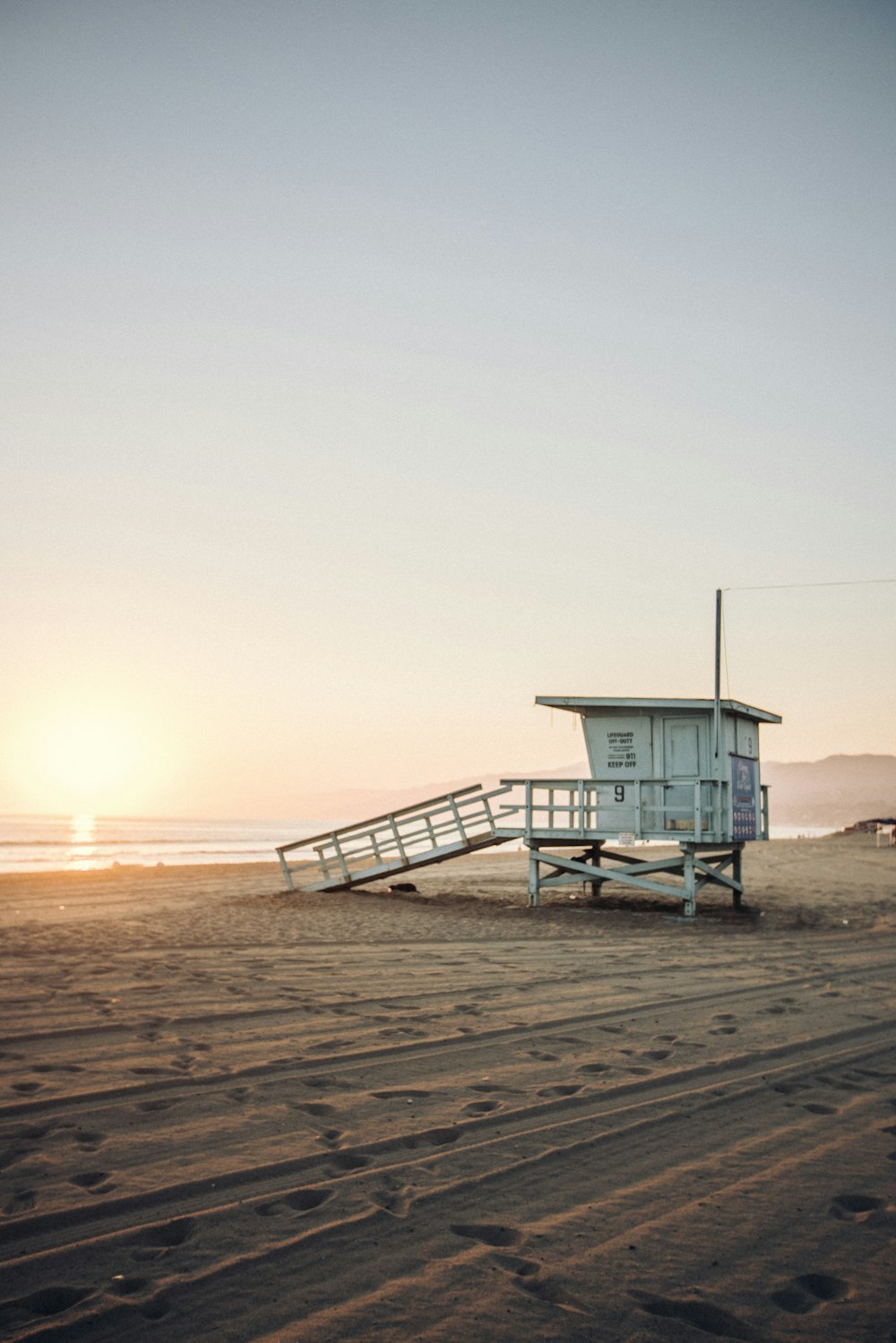 a lifeguard tower on the beach with a ladder leading to it