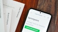 A wooden table with several documents and a smartphone. The documents are titled 'User Persona', 'Brand Colours', and 'Sprintpoint'. The smartphone displays a webpage for 'Sprintpoint', which offers strategy tools for growing businesses.