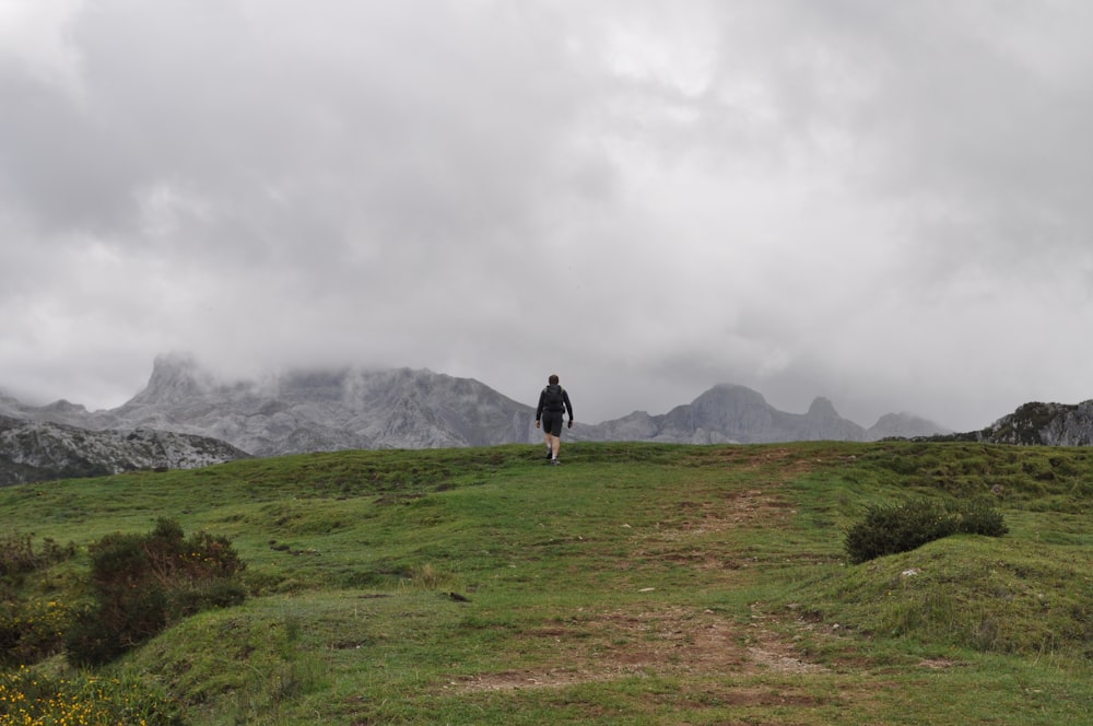 a man standing on top of a lush green hillside