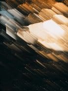 Abstract light streaks and film grain overlay on a dark, moody background.