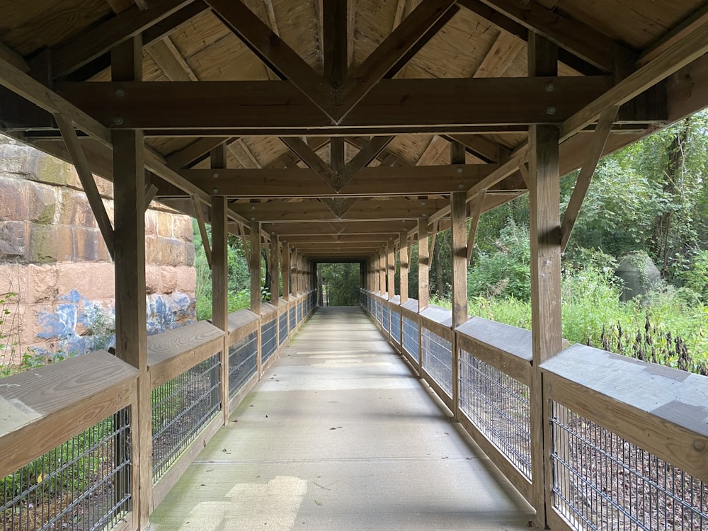 a long walkway with a wooden roof and railings