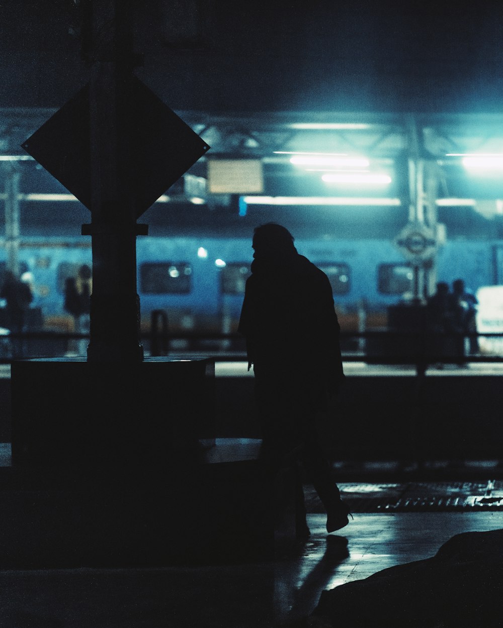 a man standing on a train platform at night