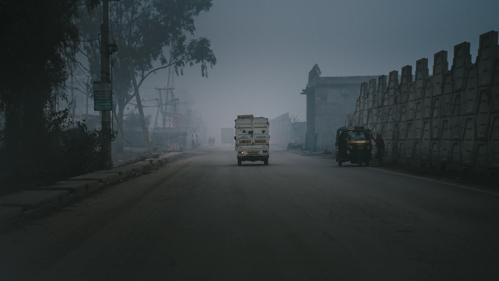 A truck driving down a street in thick smog