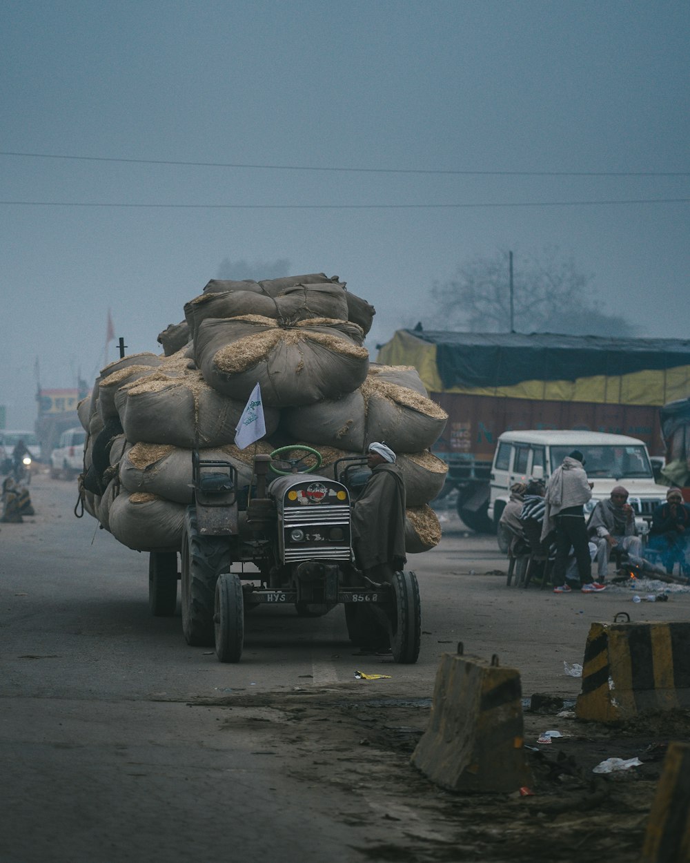 a truck with bags on the back driving down a street