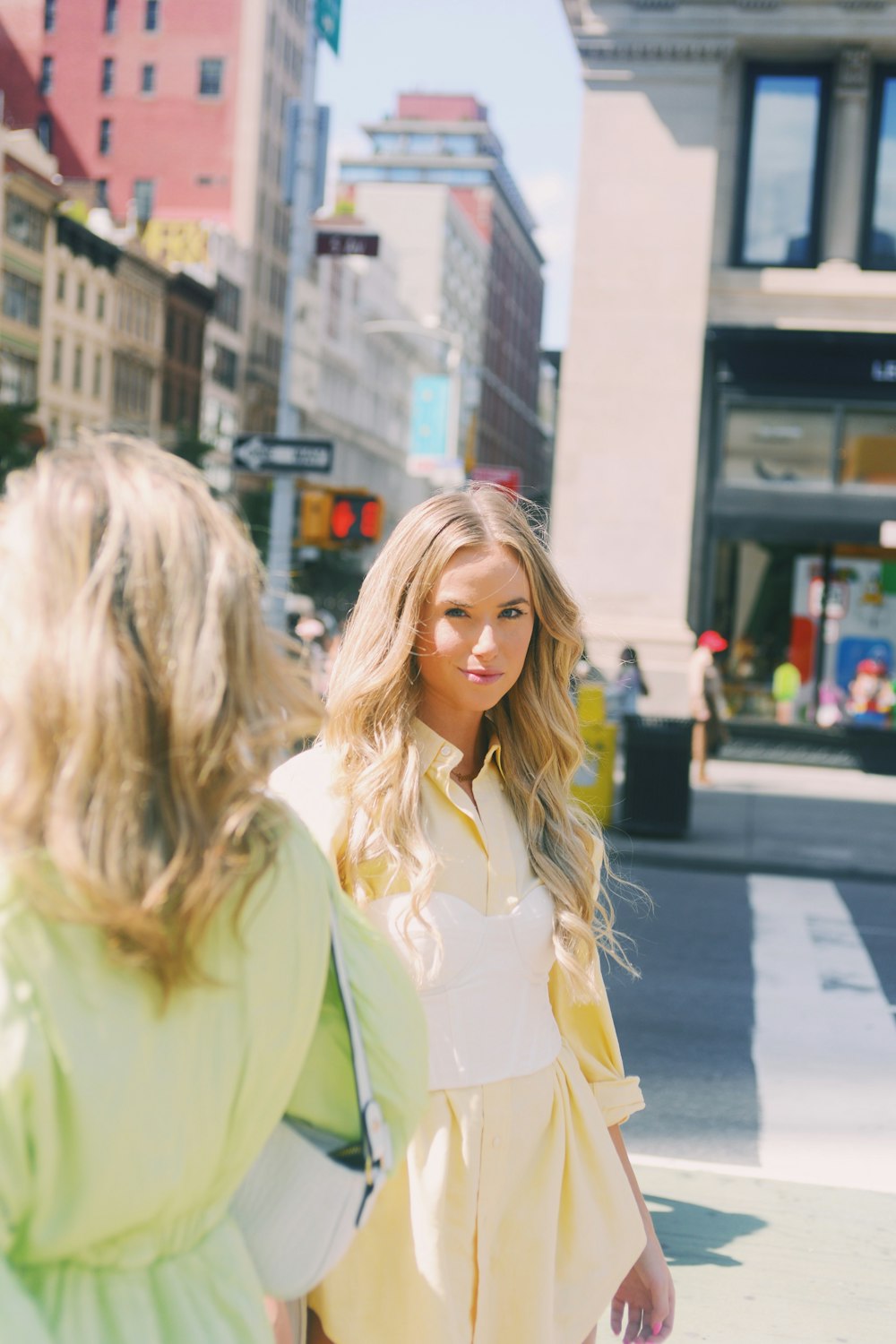 a woman standing next to another woman on a street