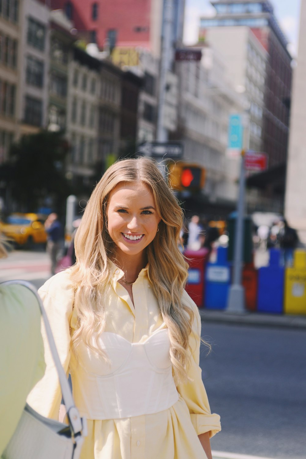 a woman in a yellow dress is walking down the street