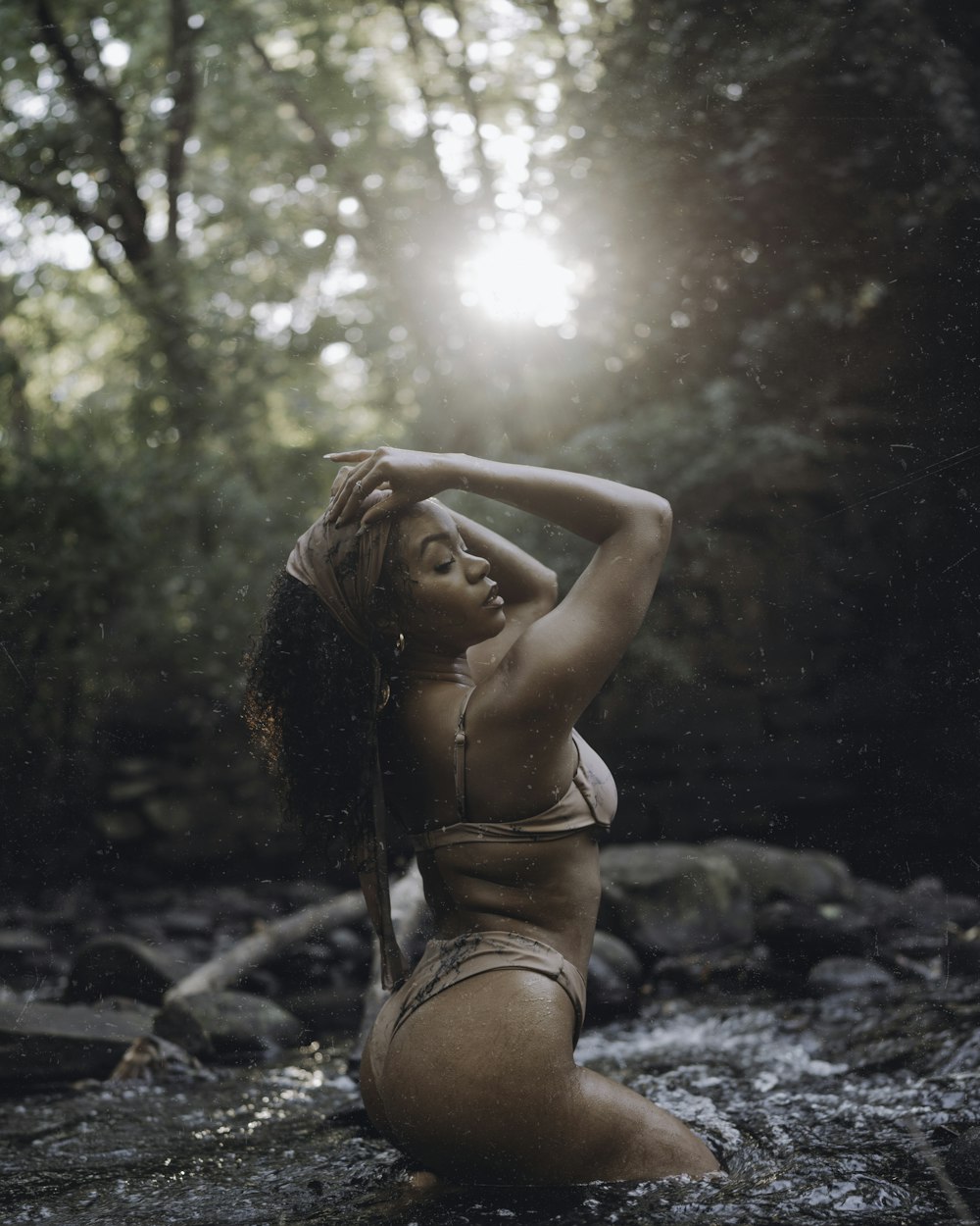 Una mujer en bikini sentada en un río