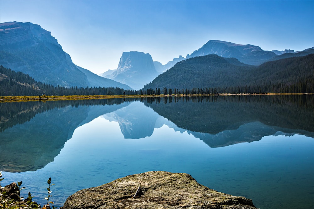 a mountain range is reflected in a still lake