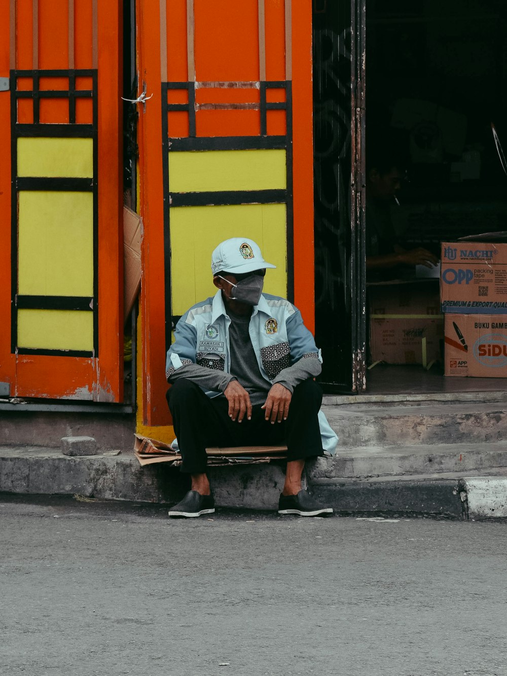 a man sitting on a bench in front of a building