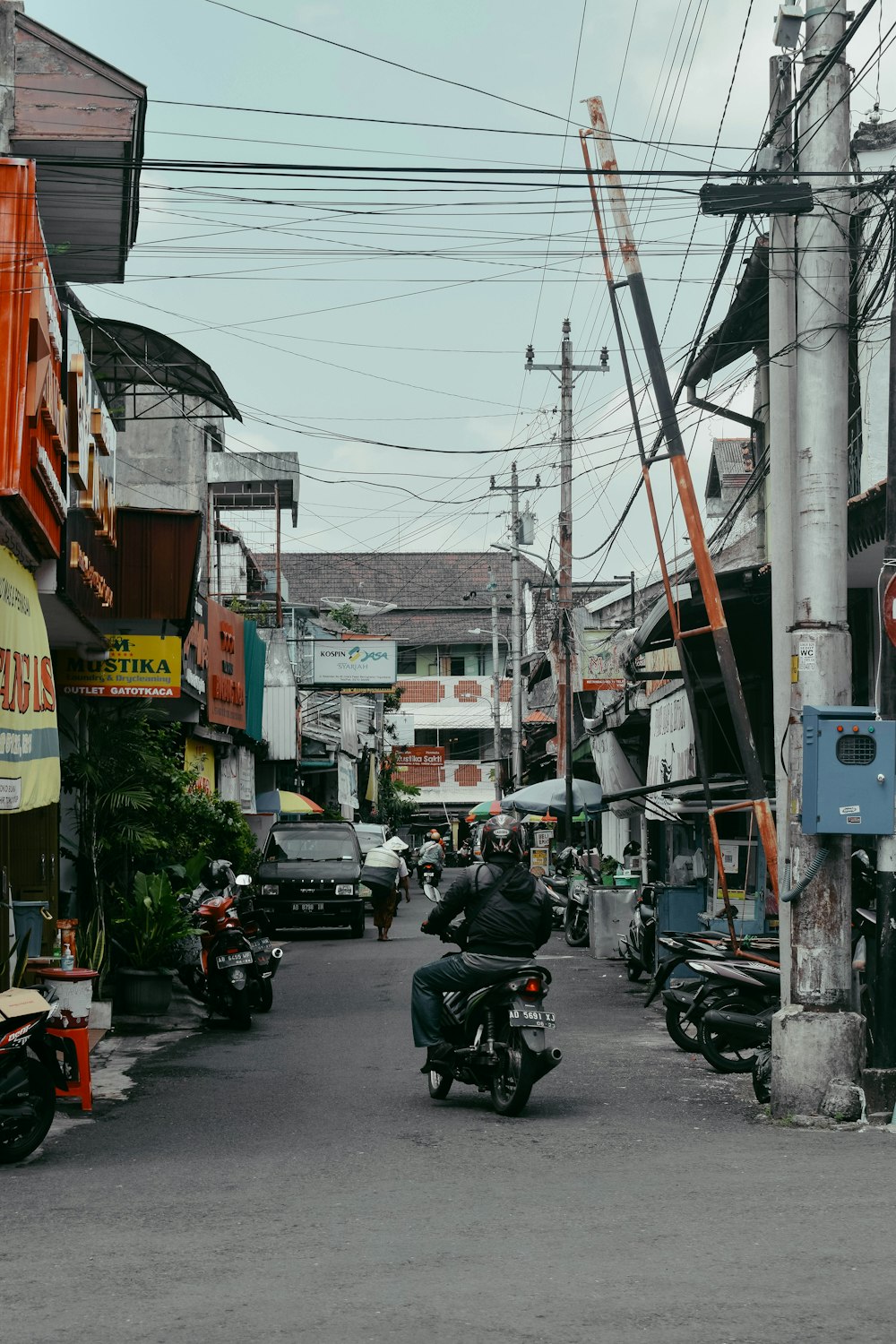 a motorcyclist riding down a street in a city