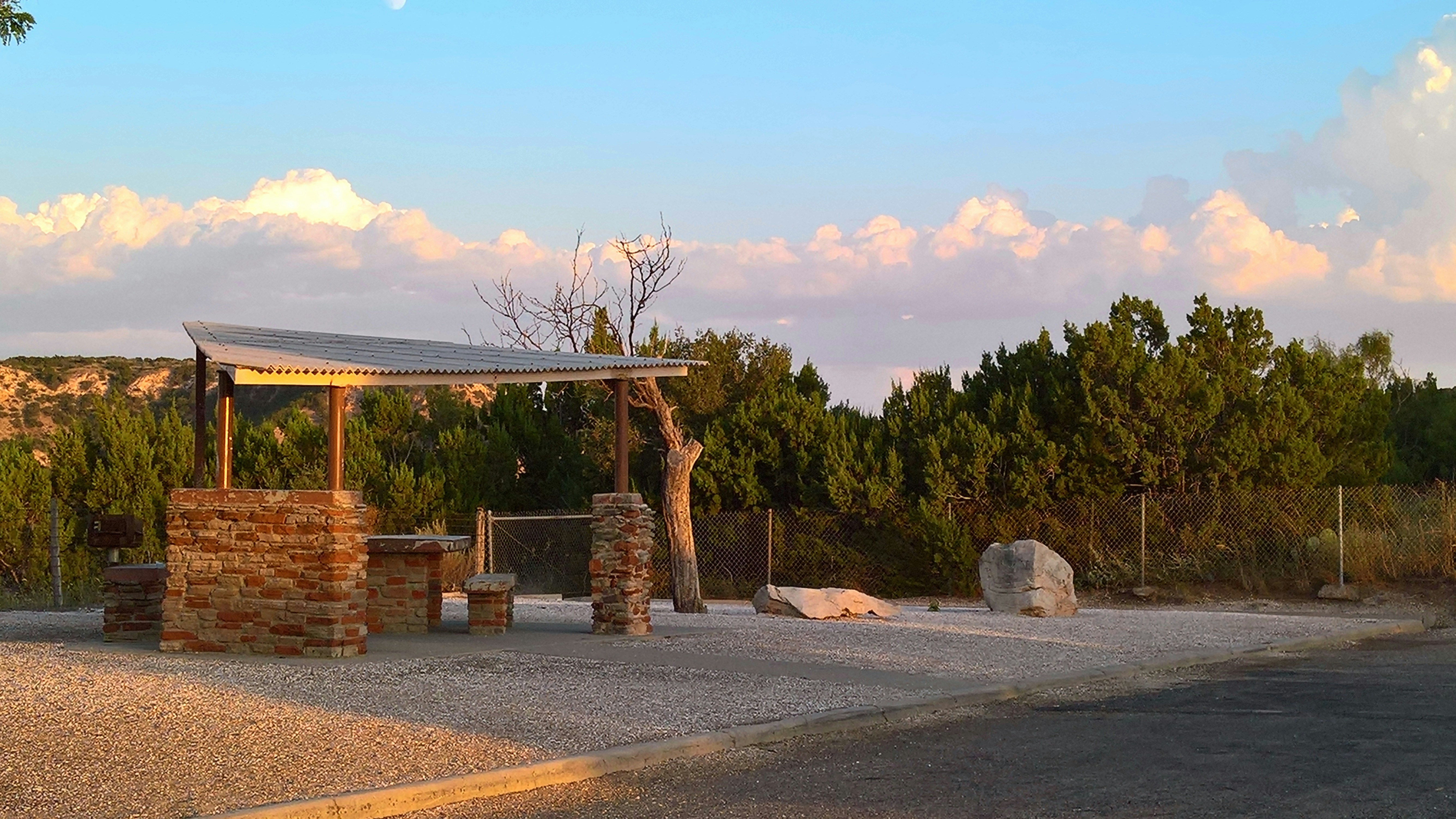 a stone structure in the middle of a gravel road