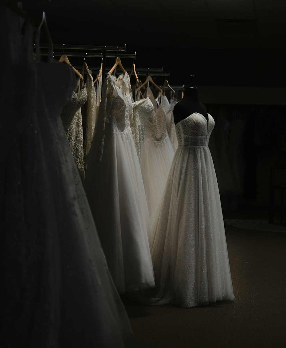 uma fileira de vestidos de noiva pendurados em um rack