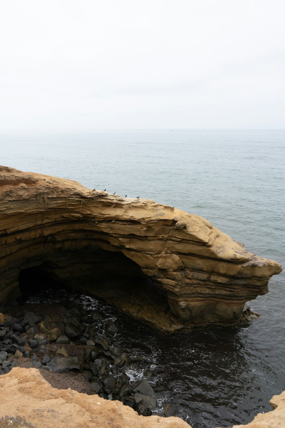 a large rock formation in the middle of a body of water