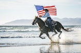a woman riding a horse with an american flag on its back