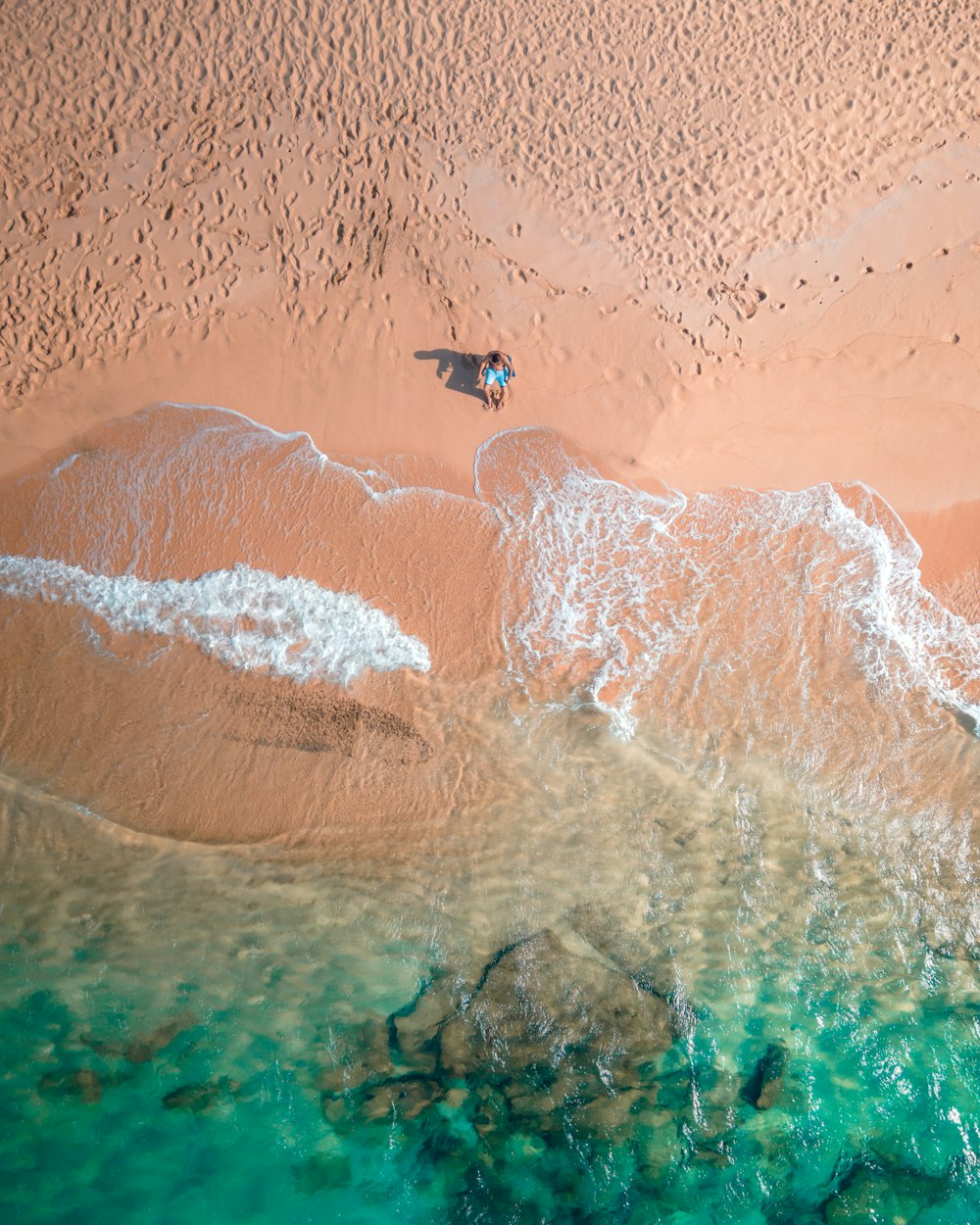 an aerial view of a sandy beach and a body of water