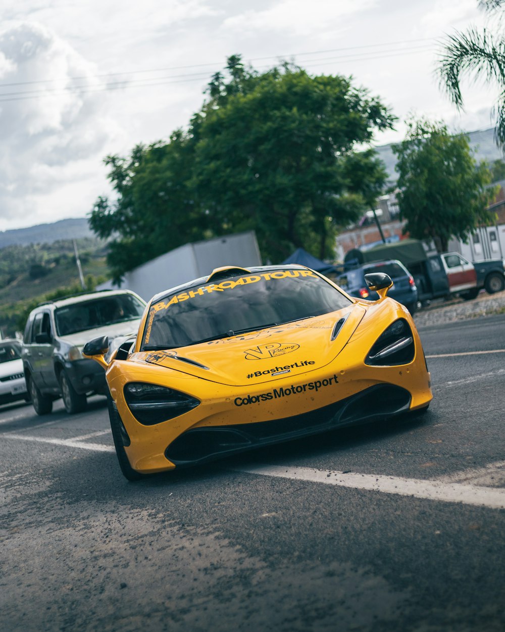 a yellow sports car driving down a street