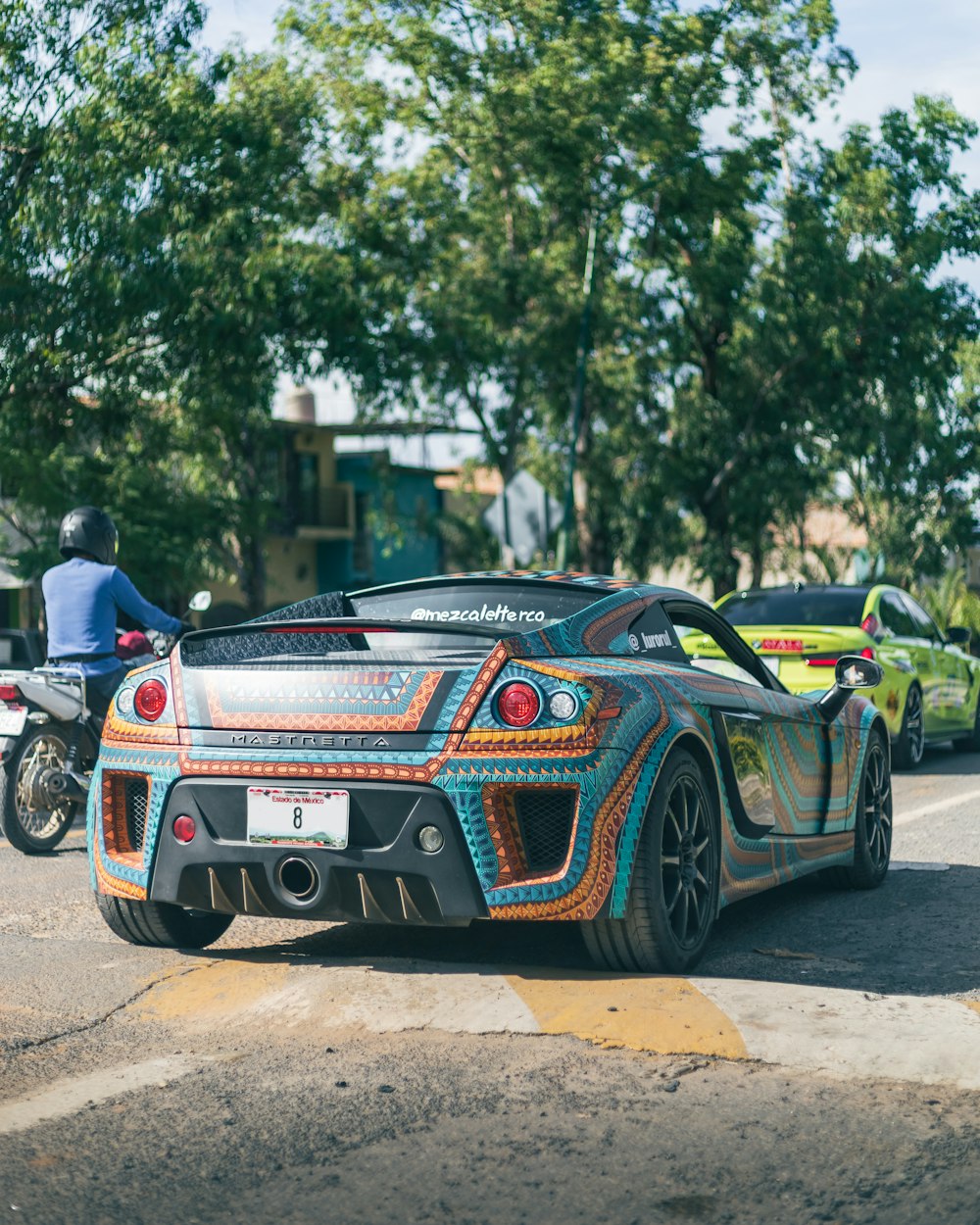 a colorful car parked on the side of the road