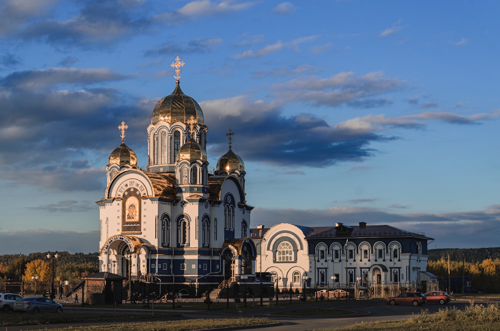 a large white and gold building with a cross on top