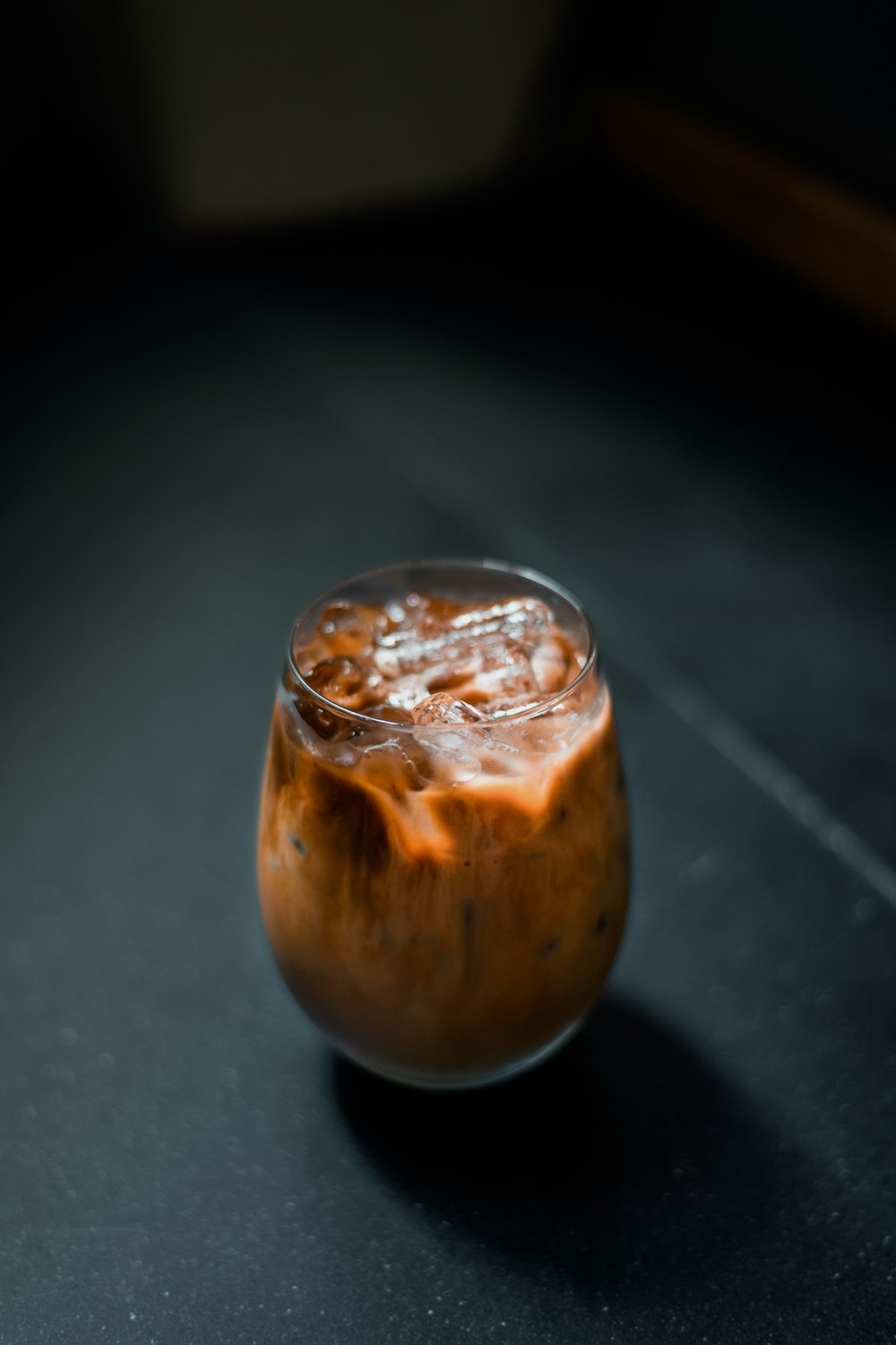 a glass filled with liquid sitting on top of a table