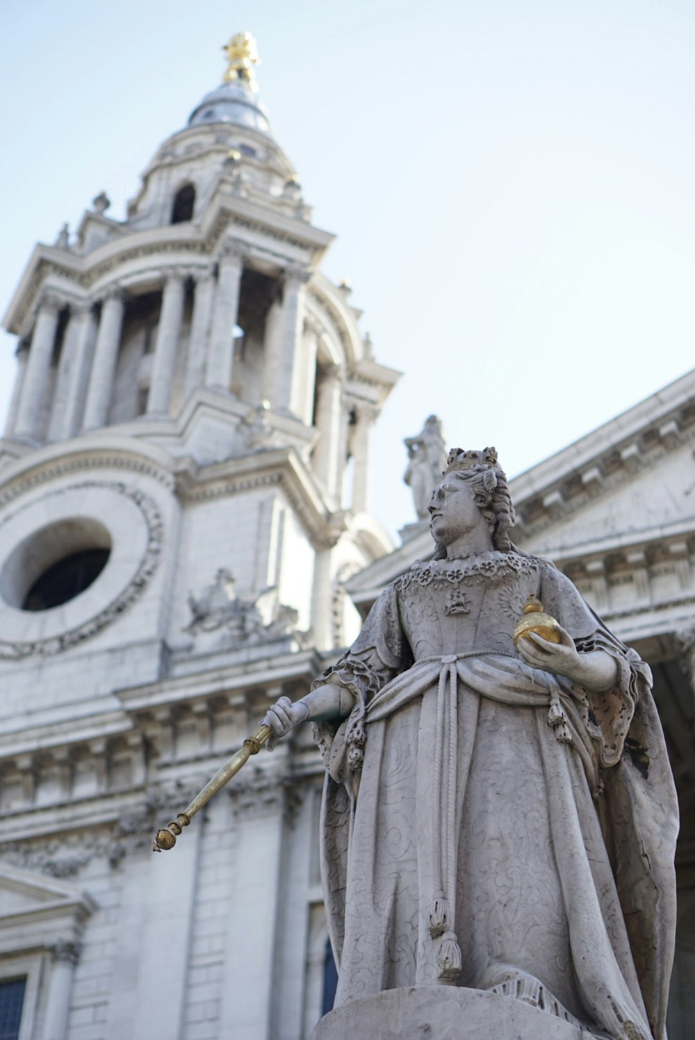 a statue in front of a building with a clock tower