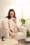 a woman sitting in a chair holding a cell phone