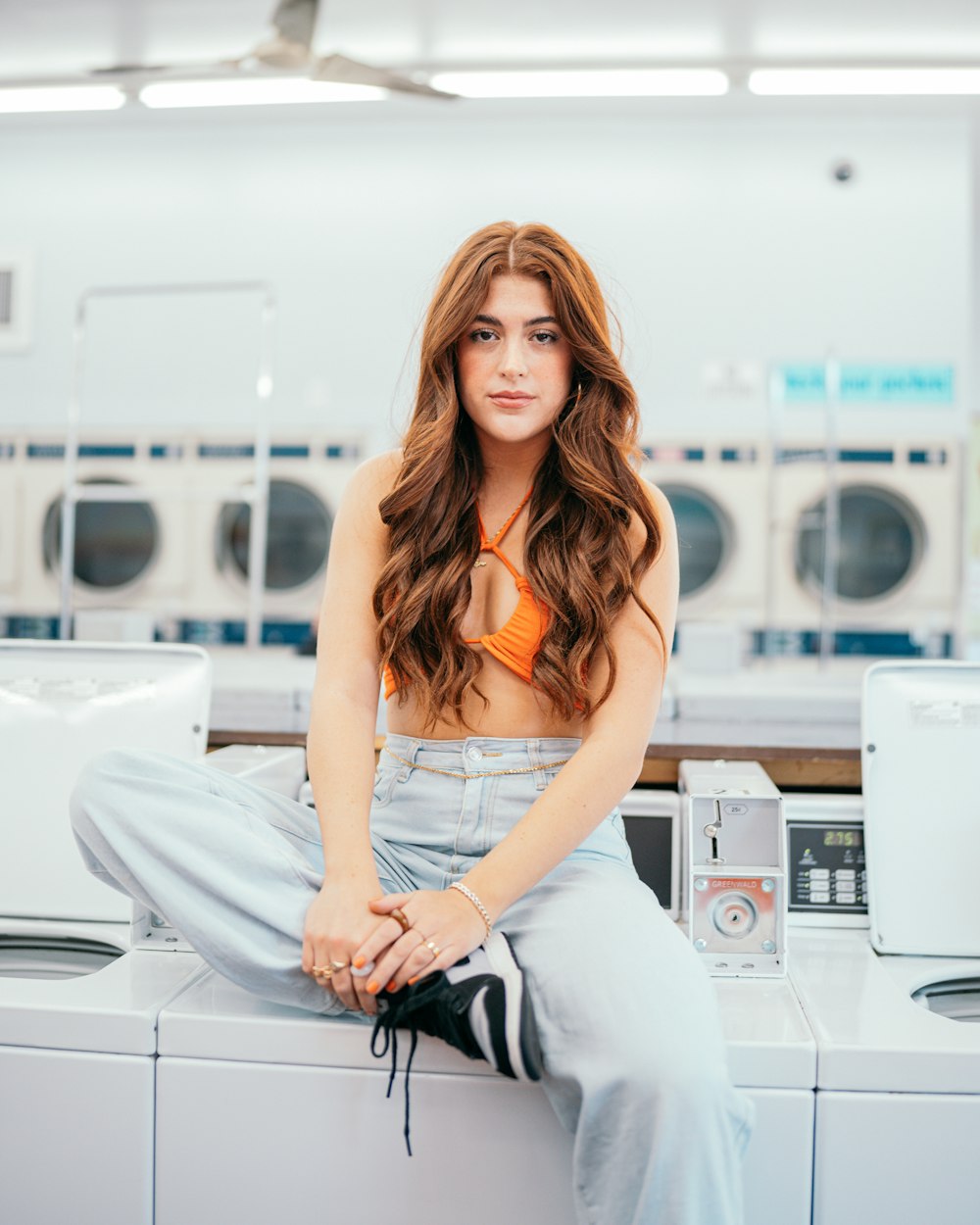 a woman sitting on top of a washing machine