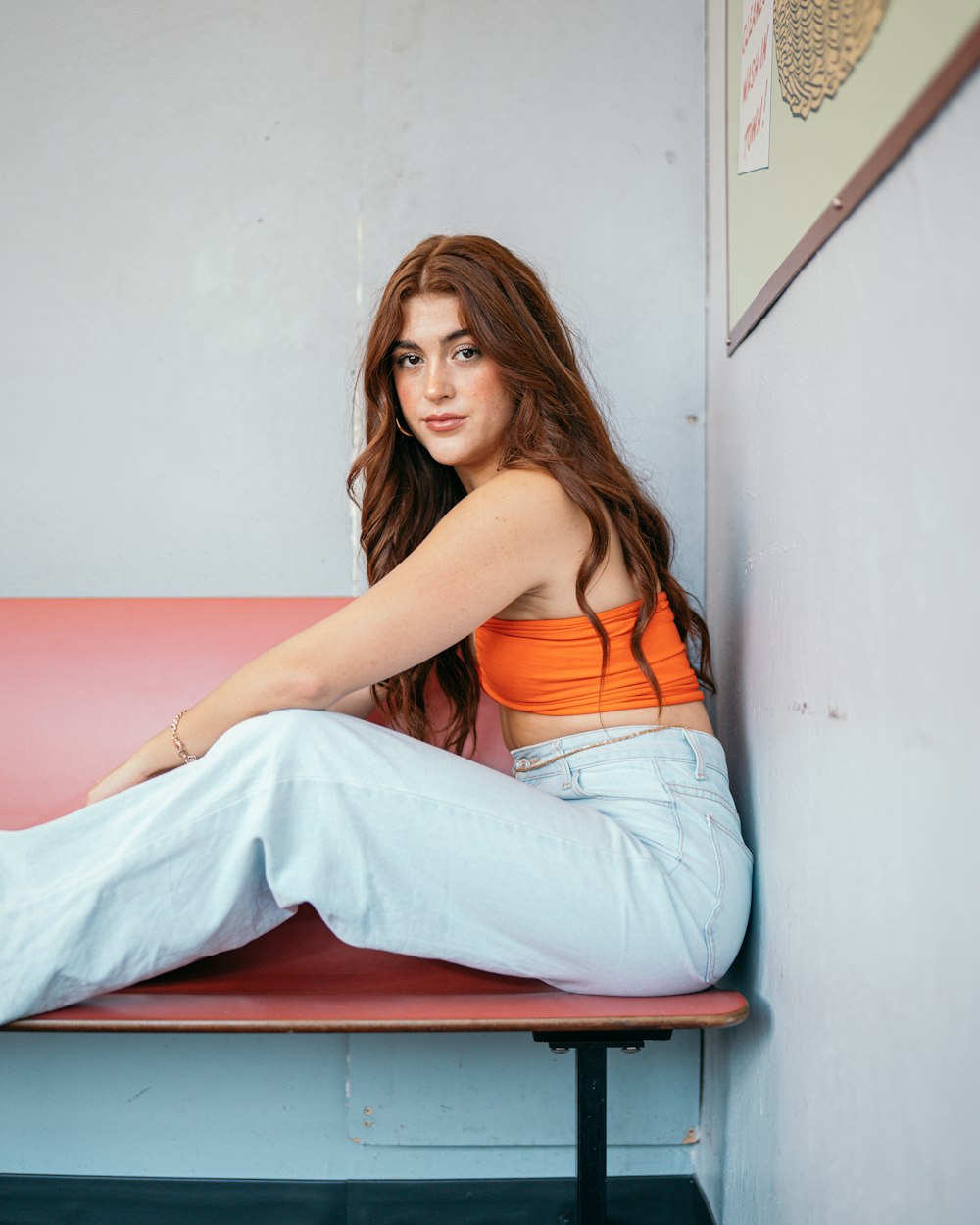 a woman sitting on a bench with her legs crossed